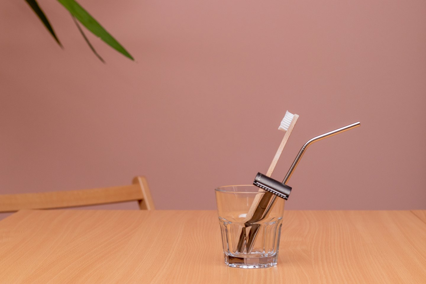 Bezobalové potřeby pro osobní hygienu ve sklenici na stole.